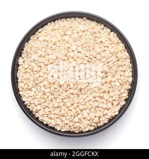 Makronaht von Organic Split poliert White urad dal (Vigna mungo) auf einer schwarzen Keramikschale. Draufsicht Stockfoto