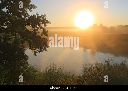 Morgenlandschaft mit Sonnenaufgang über kleinem See in Steppe Stockfoto