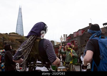 London, Großbritannien. August 2021. The Shard inszeniert die Szene, als eine Gruppe von Trommlern ihren marsch durch den Borough Market pausiert, um Mitglieder der Öffentlichkeit während des Aussterbens zu informieren RebellionÕs Stoppt den Harm-Protest am neunten Tag ihrer Impossible Rebellion-Proteste in London, Großbritannien, am 31. August 2021.Kieran Riley/Pathos Credit: One Up Top Editorial Images/Alamy Live News Stockfoto