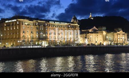 San Sebastian, Spanien - 29 Aug 2021: Lichter der alten Stadtgebäude spiegeln sich am Urumea-Fluss Stockfoto