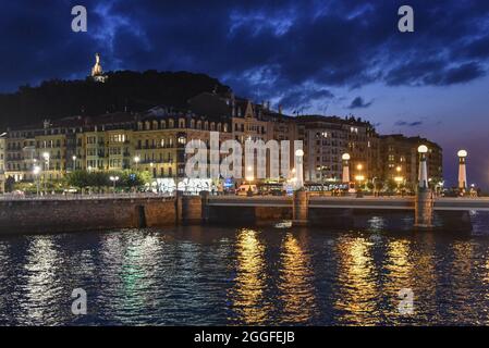 San Sebastian, Spanien - 29 Aug 2021: Lichter der alten Stadtgebäude spiegeln sich am Urumea-Fluss Stockfoto