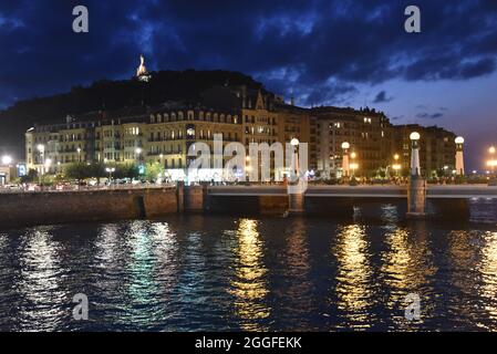 San Sebastian, Spanien - 29 Aug 2021: Lichter der alten Stadtgebäude spiegeln sich am Urumea-Fluss Stockfoto