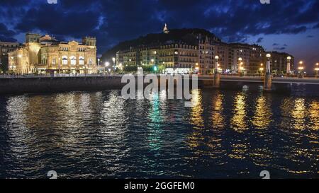 San Sebastian, Spanien - 29 Aug 2021: Lichter der alten Stadtgebäude spiegeln sich am Urumea-Fluss Stockfoto