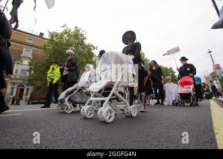 Extinction Rebellion-Aktivisten London 31. August 2021. Kinderwagenaktion Demonstranten im Zentrum von London gehen mit geisterhaften weißen Kinderwagen, die in Trauerkleidern gekleidet sind Stockfoto
