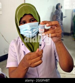 Ein Gesundheitsmitarbeiter bereitet einer Person während einer Massenimpfkampagne gegen die Covid-19-Krankheit am 31. August 2021 im Impfzentrum des Sheikh Hasina Burn Institute in Dhaka, Bangladesch, die Impfstofferhöhungsdosis von Moderna vor. (Foto von Habibur Rahman / Eyepix Group) Stockfoto