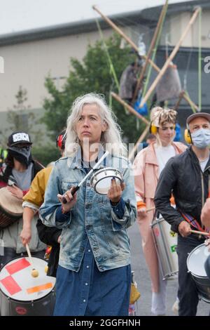 Aylesbury, Großbritannien. August 2021. Ein Protestler, der Trommeln spielt, als 50 Animal Rebels Arlas Hauptmilchfabrik in Aylesbury stillgelegt haben, indem er den Eingang mit Leuchttürmen, Rebellen und Fahrzeugen blockierte. Die Rebellen wollen eine Verpflichtung von Arla, die Milchproduktion zu beenden und bis 2025 vollständig pflanzenbasiert zu sein, um das Leid von Milliarden von Menschenleben zu beenden und die Klimakrise abzuwenden. Kredit: SOPA Images Limited/Alamy Live Nachrichten Stockfoto