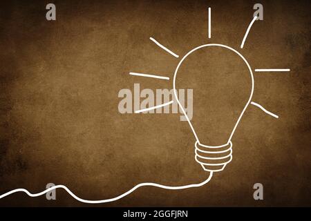Weiße Lampe auf einem strukturierten braunen Hintergrund, Symbol für Idee, Kreativität, Geschäft, Planung Stockfoto