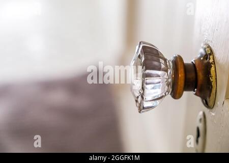 Ein antikes Vintage Glas Türknauf zu einem schmalen Badezimmer in einem kleinen Häuschen Stockfoto