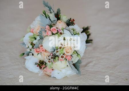 Schöner Hochzeitsstrauß aus roten und rosa Rosen auf einem Beibettlaken platziert Stockfoto