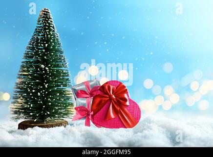 Weihnachtstanne und Geschenke auf blauem Hintergrund mit Schnee. Stockfoto