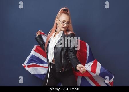 Junge Frau Expat in Brillen mit Großbritannien Flagge. Studioaufnahme. Hipster-Lehrerin in englischer Sprache Stockfoto