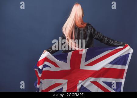 Junge Frau Expat in Brillen mit Großbritannien Flagge. Studioaufnahme. Hipster-Lehrerin in englischer Sprache Stockfoto