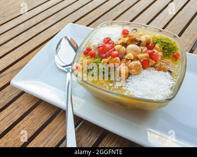 Köstlicher Aschrein auf dem Tisch im Restaurant. Noahs Pudding ist ein türkischer Dessertbrei, der aus einer Mischung aus Getreide, Früchten und getrockneten Fré besteht Stockfoto