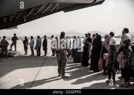 Evakuierte warten während einer Evakuierung auf dem Hamid Karzai International Airport, Kabul, Afghanistan, am 30. August auf den Einsteigen in eine Boeing C-17 Globemaster III. US-Dienstmitglieder unterstützen das Außenministerium bei einer nicht-kämpferischen Evakuierungsoperation (NEO) in Afghanistan. (USA Marine Corps Foto von Staff Sgt. Victor Mancillal) Stockfoto