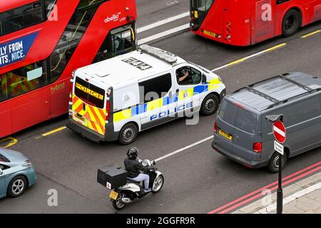 London, England - 2021. August: Polizeiwagen mit blauen Lichtern, die eine Straße im Zentrum Londons entlang fahren Stockfoto