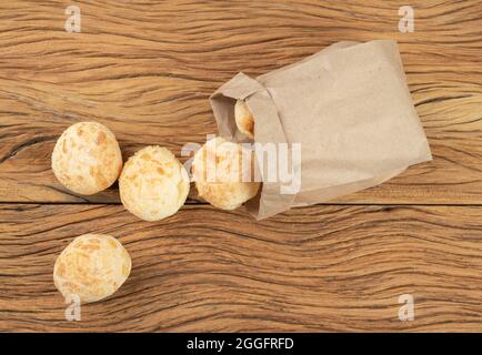 Typische brasilianische Käsebrühen in einem Papierbeutel über einem Holztisch. Stockfoto