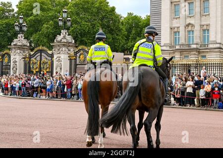 London, England - 2021. August: Zwei Polizisten auf Pferden vor dem Buckingham Palace zur Wachablösung. Stockfoto