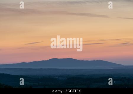 Berg im Dunst und wunderschöne lebendige Farben am Himmel in der Dämmerung Stockfoto