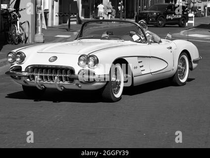 Ein Mann fährt mit seinem alten Chevrolet Corvette Cabriolet aus dem Jahr 1959 an einer Straße in der Innenstadt von Santa Fe, New Mexico. Stockfoto