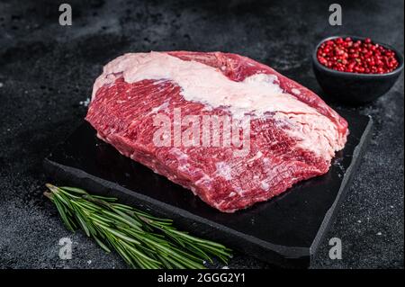 Außen roh Rundes Rinderbraten auf Marmorplatte geschnitten. Schwarzer Hintergrund. Draufsicht Stockfoto