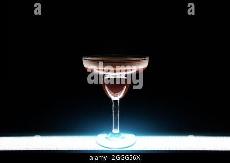 Luxuriöser Espresso martini-Cocktaildrink in elegantem Glas auf schwarzem Hintergrund Stockfoto