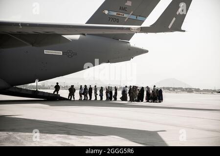 Evakuierte warten während einer Evakuierung auf dem Hamid Karzai International Airport, Kabul, Afghanistan, am 30. August auf den Einsteigen in eine Boeing C-17 Globemaster III. US-Dienstmitglieder unterstützen das Außenministerium bei einer nicht-kämpferischen Evakuierungsoperation (NEO) in Afghanistan. (USA Marine Corps Foto von Staff Sgt. Victor Mancillal) Stockfoto