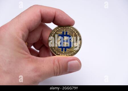 Männer Hand Finger halten Bitcoin-Münze Krypto-Währung - BTC elektronische virtuelle Geld für Web-Banking und internationale Netzwerk-Zahlung. Stockfoto