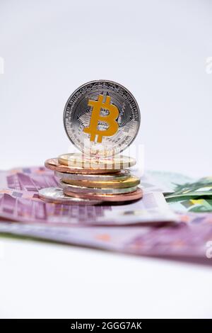 Bitcoin auf den oberen 100 und 500 Euro Banknoten. Silberne Bitcoin auf hundertfünfhundert Euro-Banknoten. Kryptowährungskonzept, Bitcoin und Euro. Stockfoto