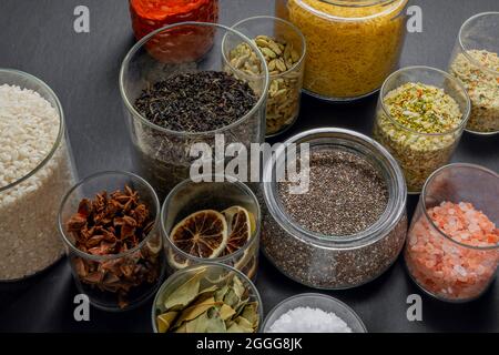 Glasgläser mit Tee, Kardamom, getrockneten Zitronenscheiben, Anise, Himalaya-Salz und mehr gute Dinge Stockfoto