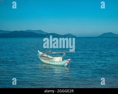 Ein kleines Fischerboot ist in der Nähe der Küste in der Bucht von Nha Trang, Vietnam, verankert Stockfoto