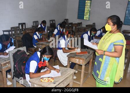 Schüler mit Gesichtsmasken halten sich während des Klassenbesuchs an einer staatlichen Mädchenschule inmitten des anhaltenden Covid-19-Coronavirus in sozialer Distanz. Stockfoto