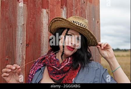 Umea, Norrland Schweden - 21. August 2021: cowgirl in der roten Scheune auf dem Feld Stockfoto