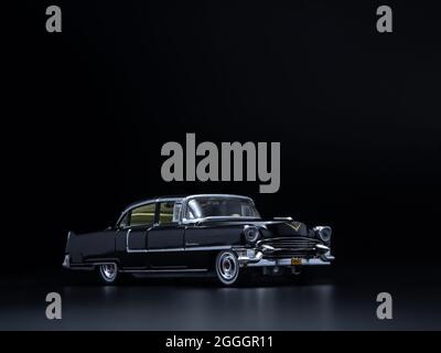 Greenlight schwarz im Maßstab 1:1/64 Cadillac Fleetwood Spielzeugauto aus Diecast im Maßstab 1:1955 auf dunkelschwarzem Hintergrund Stockfoto