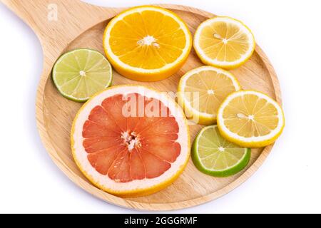 Bunte Scheiben von Zitrusfrüchten auf einem Holztablett Stockfoto