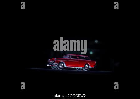 Greenlight Red 1955 Chevrolet Nomad Spielzeugauto im Maßstab 1:1/64 auf dunkelschwarzem Hintergrund Stockfoto