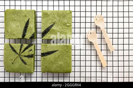 Bars mit leckeren Matcha Cannabis weißen Schokoladenkuchen auf einem Kühlregal. Stockfoto