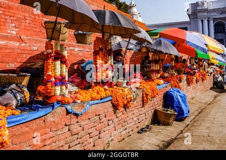 Ringelblumen-Girlande-Verkäufer auf der Treppe des Maju-Dega-Tempels in Kathmandu, Durbar Square, Nepal Stockfoto