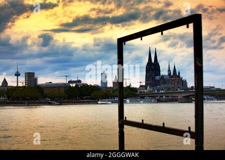 Köln, Panorama auf den Kölner Dom, der von einem leeren Wegweiser-Regal eingerahmt wird.vom rechten Rhein im Abendlicht Stockfoto