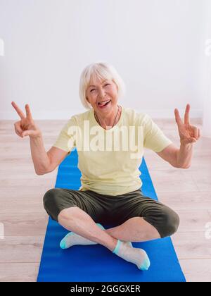 Ältere Frau, die drinnen Yoga macht. Anti-Alter, Sport, Yoga-Konzept Stockfoto
