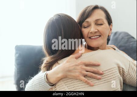 Support und Liebe Konzept. Zwei Frauen, verschiedene Generationen umarmen sich, eine ältere Mutter umarmt eine Erwachsene Tochter. Familienbande Stockfoto