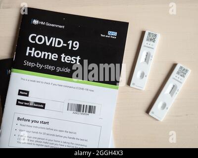 Positives COVID-19-Testergebnis. Sowohl positive als auch negative Testergebnisse eines UK NHS lateral flow Corona Virus Home Testkits mit Benutzerhandbuch.