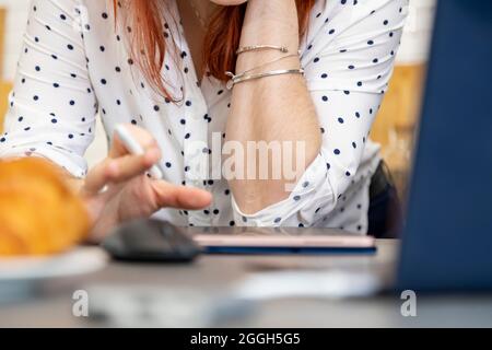 Frau zeichnet mit einem Stift auf einem Tablet. Weibliche Hände arbeiten auf einem Tablet-Computer. Creative profession.no Gesicht Stockfoto