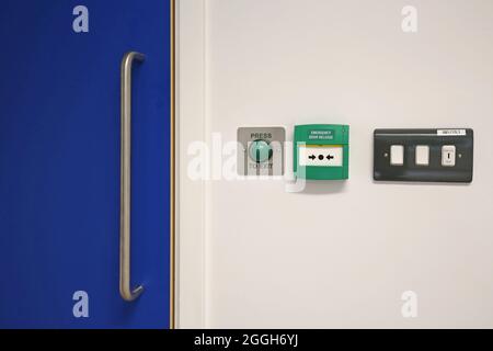 Elektronische Türentriegelungskontrollen neben einer laminierten Tür in einem neuen Londoner Gesundheitszentrum. Stockfoto