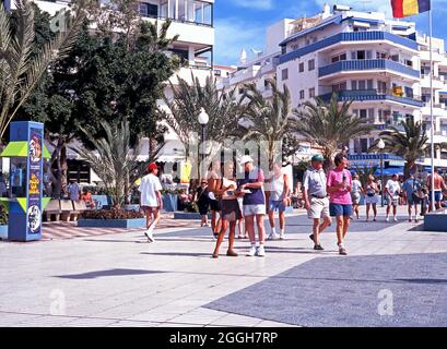 Blick auf Touristen, die entlang der Promenade, Los Cristianos, Teneriffa, Spanien, wandern. Stockfoto