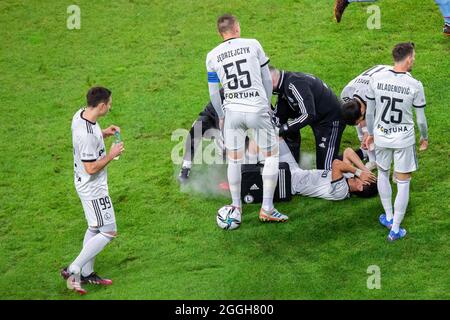 Artur Jedrzejczyk (55), Filip Mladenovic (25) und Andre Martins (8), die sich während des UEFA Europa League Play-off Qualifying Round Spiels zwischen Legia Warszawa und SK Slavia Praha im Marschall Jozef Pilsudski Legia Warsaw Municipal Stadium verletzt hatten, lagen auf dem Spielfeld. (Endstand; Legia Warszawa 2:1 SK Slavia Praha) Stockfoto