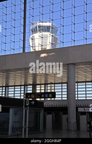 Check-in-Halle in Terminal 3 Abflughalle mit dem Kontrollturm nach hinten durch das Fenster am Flughafen Málaga gesehen. Stockfoto