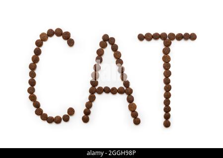 Trockenes Katzenfutter in Form von Buchstaben CAT, isoliert auf weißem Hintergrund, Kopierraum, Draufsicht. Das Konzept der Liebe für Haustiere. Futter für Katzen und Hunde. Hea Stockfoto