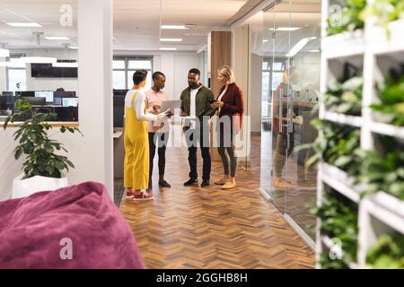 Verschiedene Kollegen und Kolleginnen, die mit einem Laptop zusammenarbeiten Stockfoto