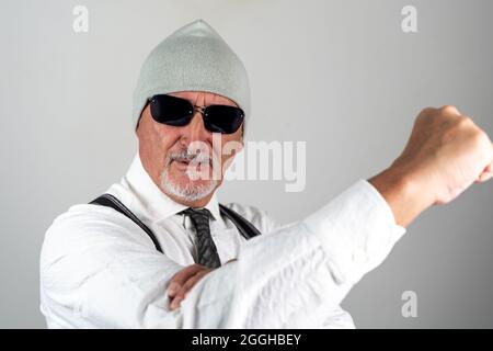 Porträt des Geschäftsmannes macht Regenschirm Geste isoliert auf grauem Hintergrund Stockfoto