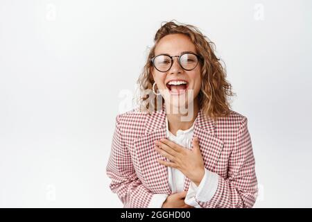 Nahaufnahme Porträt einer glücklichen Geschäftsfrau in einer Brille, die lacht, etwas Lustiges sieht, das auf weißem Hintergrund steht Stockfoto